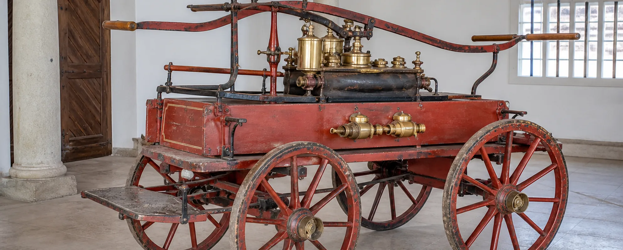 Restaurierte historische Feuerwehr-Handdruckspritze mit Holzrädern und Messingarmaturen